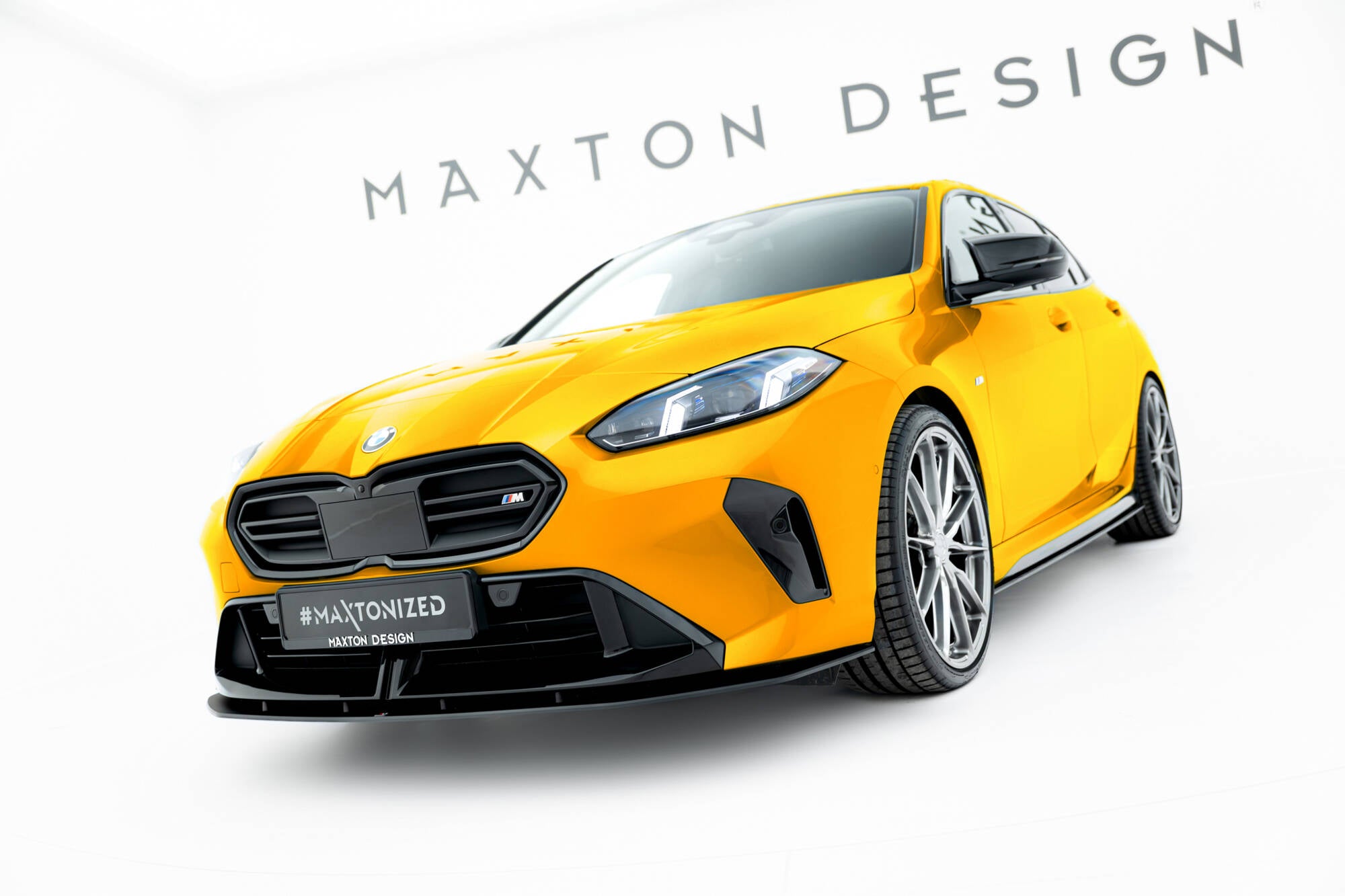 Frontspoiler BMW F70 1 M-Pakke Front V1 på gul bil med svarte detaljer og Maxton Design-logo.