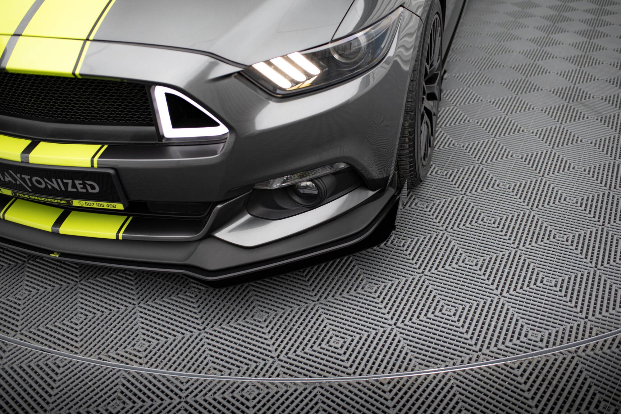 Front splitter på Ford Mustang GT MK6 med flaps, grå bil med gule striper og synlige LED-lys.