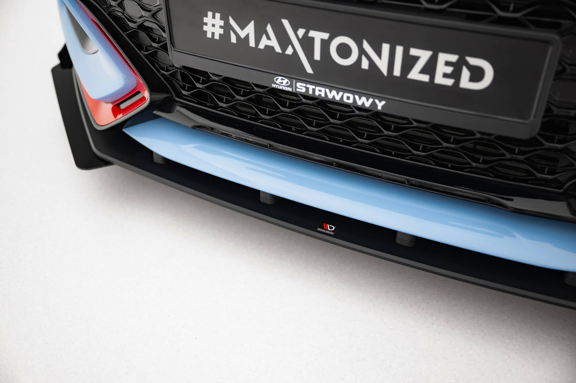Front splitter til Hyundai Veloster N MK2 med flaps, lyseblå og svart plast, røde detaljer og logo.