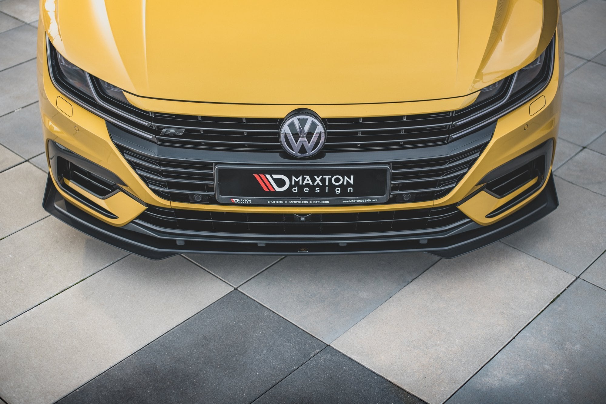 Frontspoiler VW Arteon R-Line RS i svart plast med Maxton Design-detaljer, sett ovenfra på gul bil.