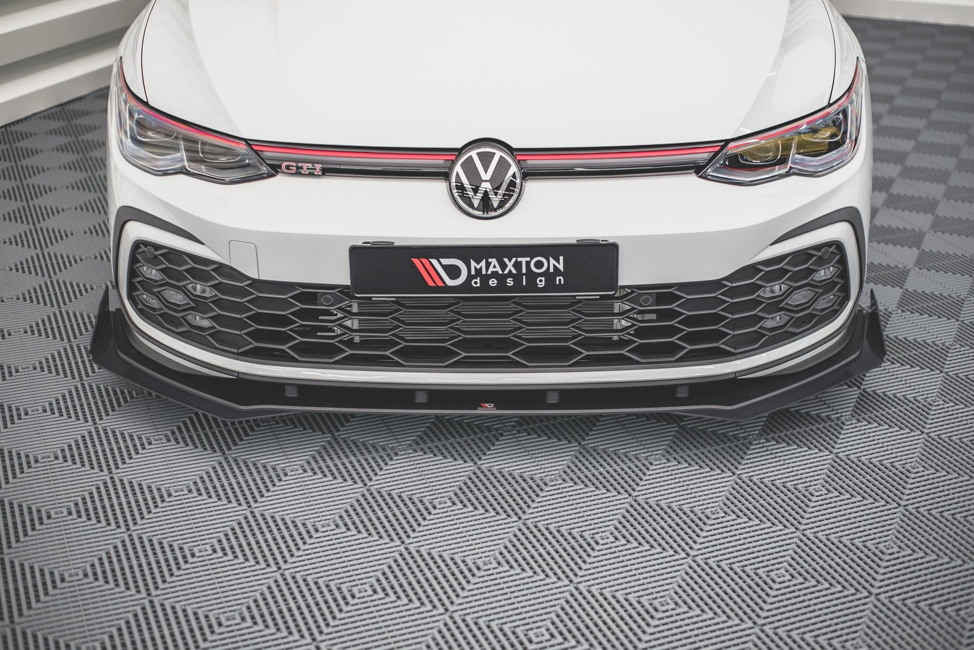Frontspoiler til VW Golf MK8 GTI med rød dekorlinje, sort grill og ekstra frontsplitter.