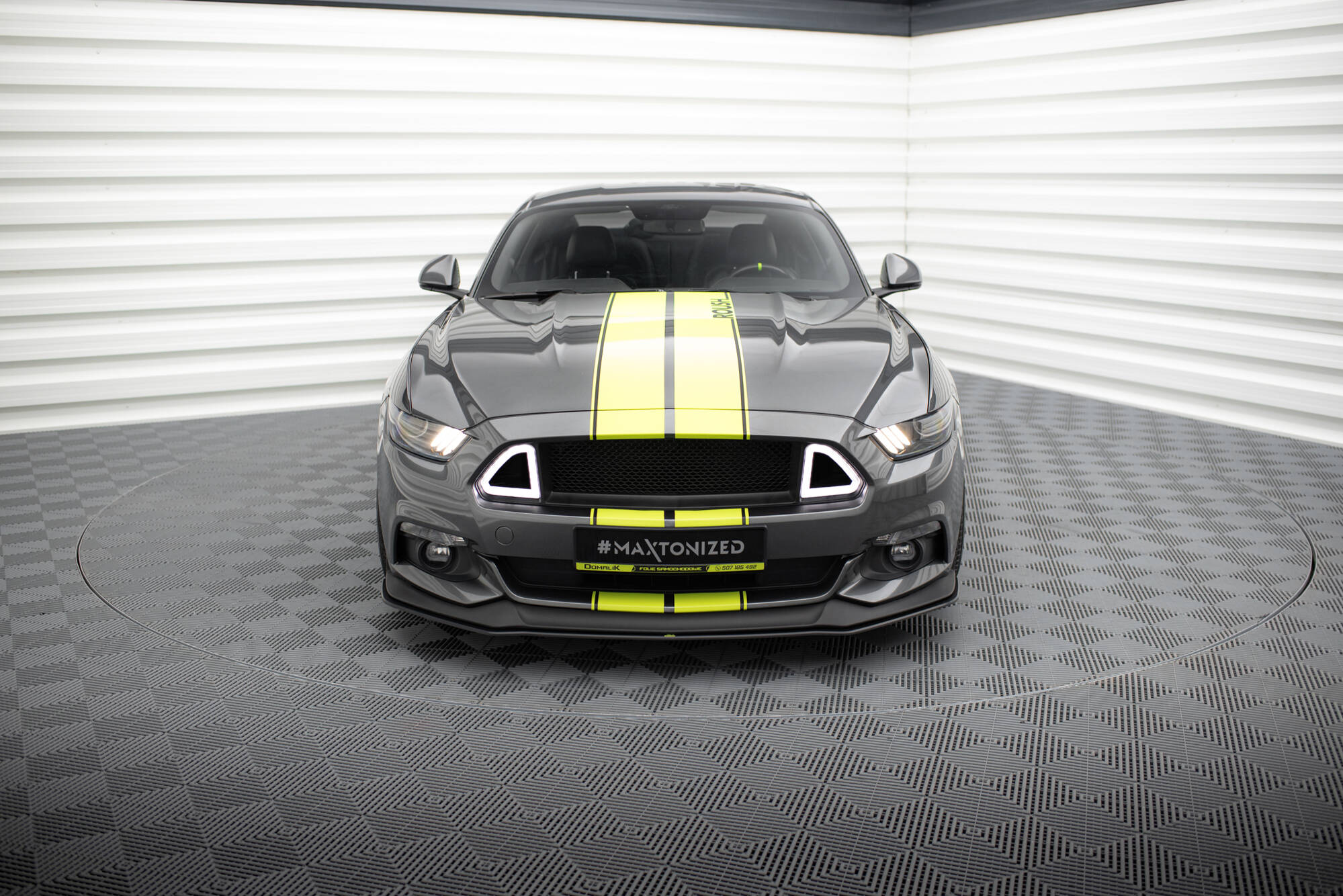 Frontleppe på Ford Mustang GT MK6 med gule racingstriper, LED-lys og sort sporty frontfanger.