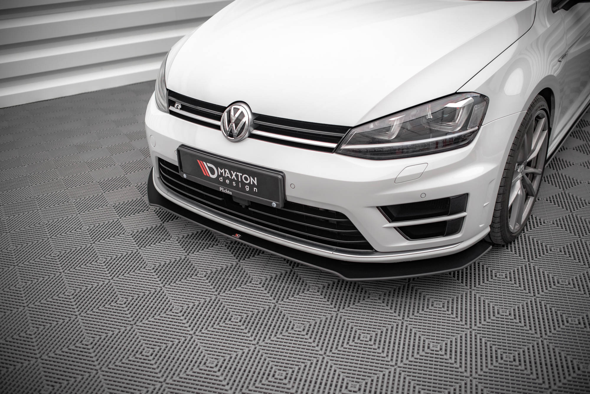 Frontleppe VW Golf R MK7 V.1 montert på hvit bil med svart splitter og LED-frontlykter, teppe under bilen.