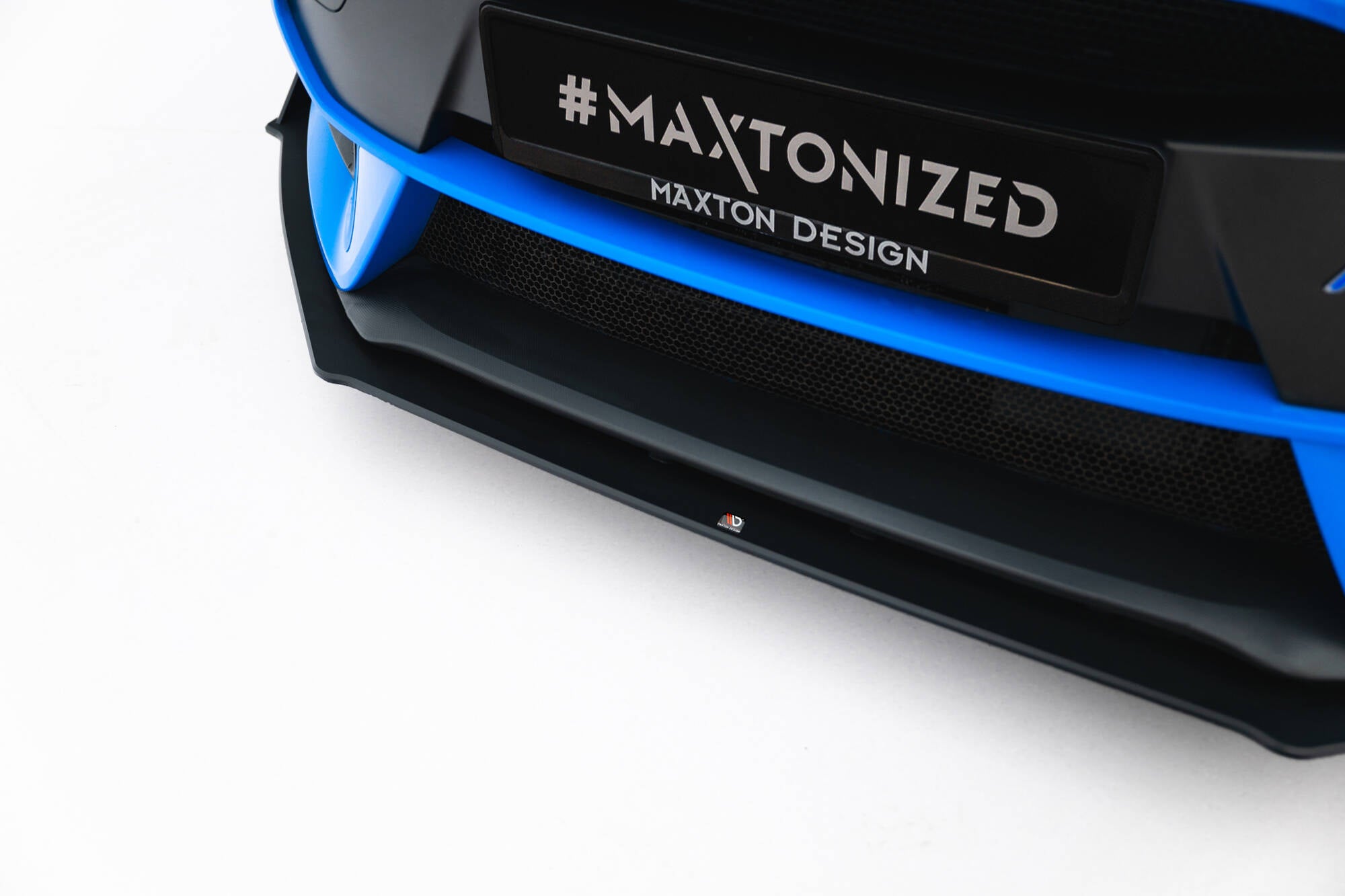 Spoiler til Ford Focus RS MK3 V.2 i blått og svart, sett skrått forfra med Maxton Design-logo.