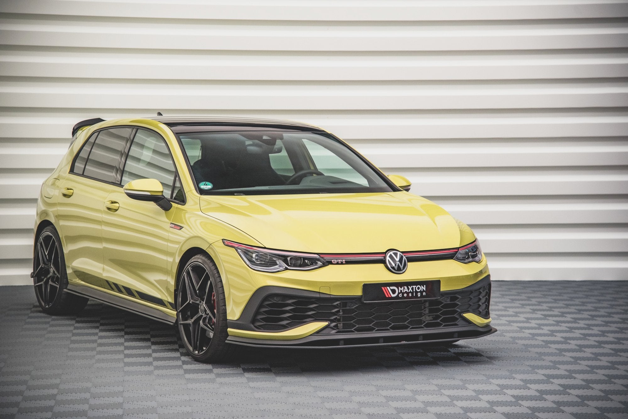 Spoiler på gul VW Golf GTI Clubsport MK8 med sorte detaljer og store aluminiumsfelger, vist fra siden.