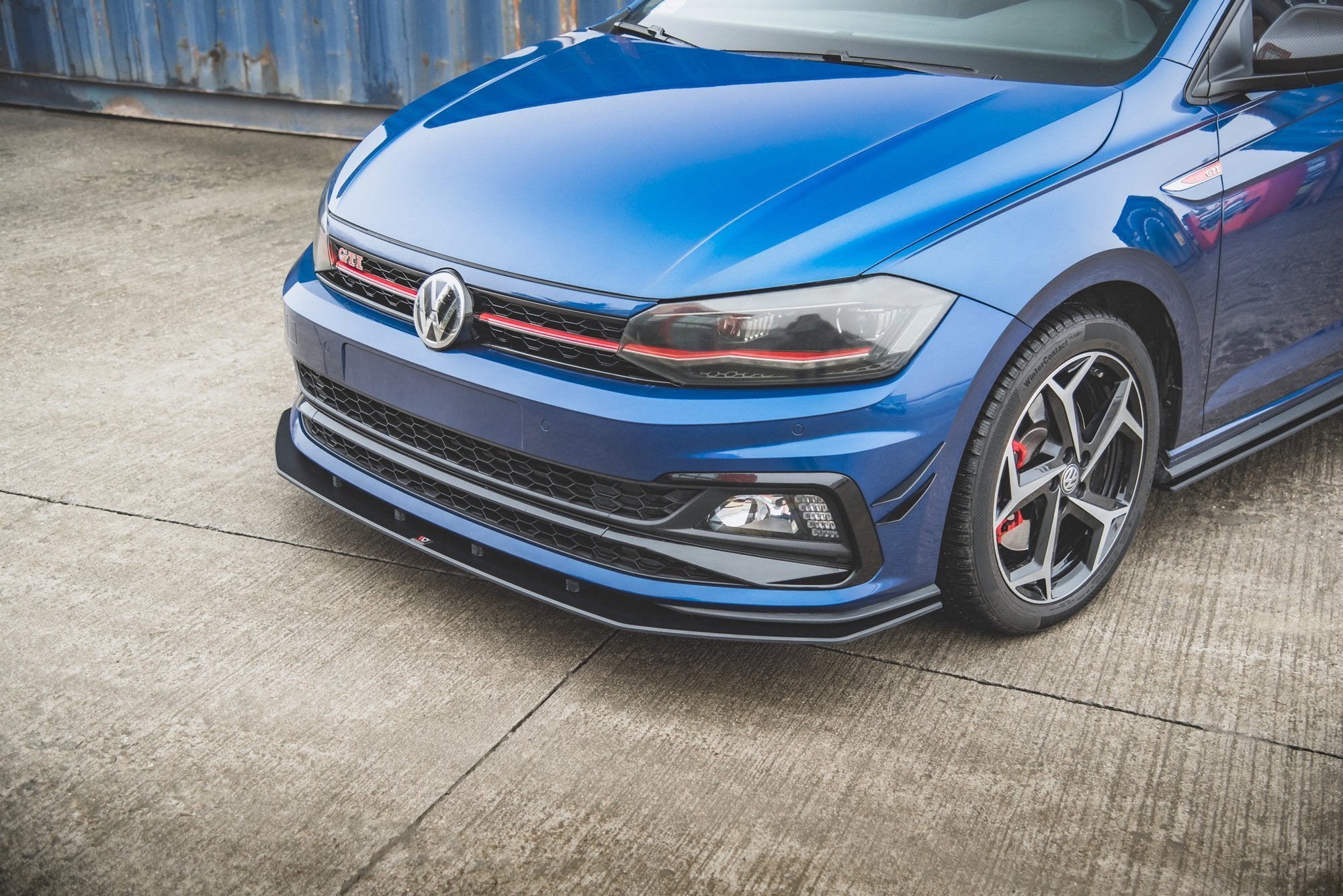 Spoiler på VW Polo GTI MK6 med blå lakk, røde detaljer, LED-lys og aluminiumsfelg med røde bremsekalipere.