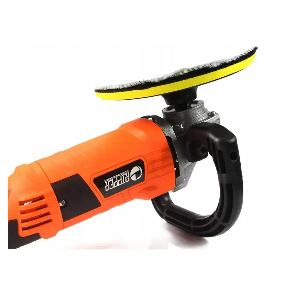 Oransje poleringsmaskin med sort håndtak, gulkantet poleringspute og hvit overflate sett fra siden.