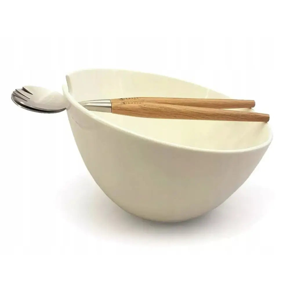 Porselensalatskål fra Kassel, sett fra siden med treskaft serveringsbestikk plassert oppå bollen.