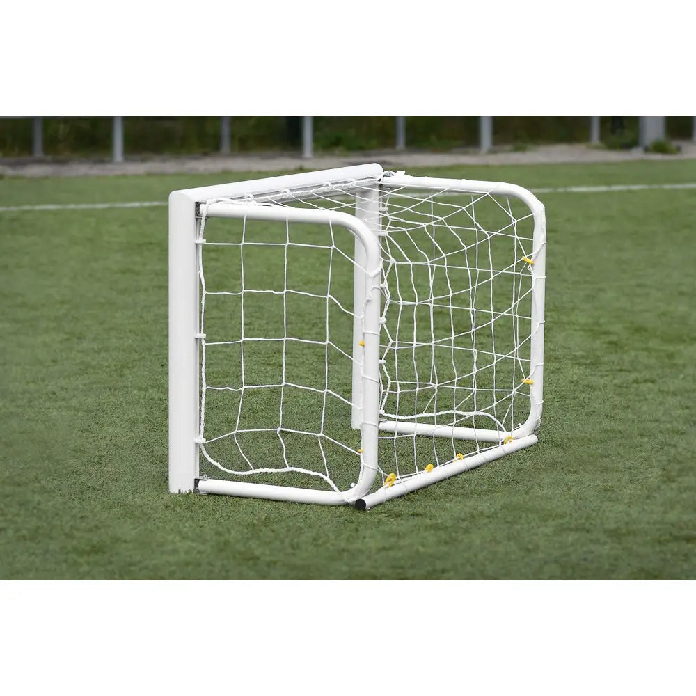 Port aluminium MINI PRO, sammenleggbart fotballmål i hvitt metall med nett, sidevisning på kunstgressbane.