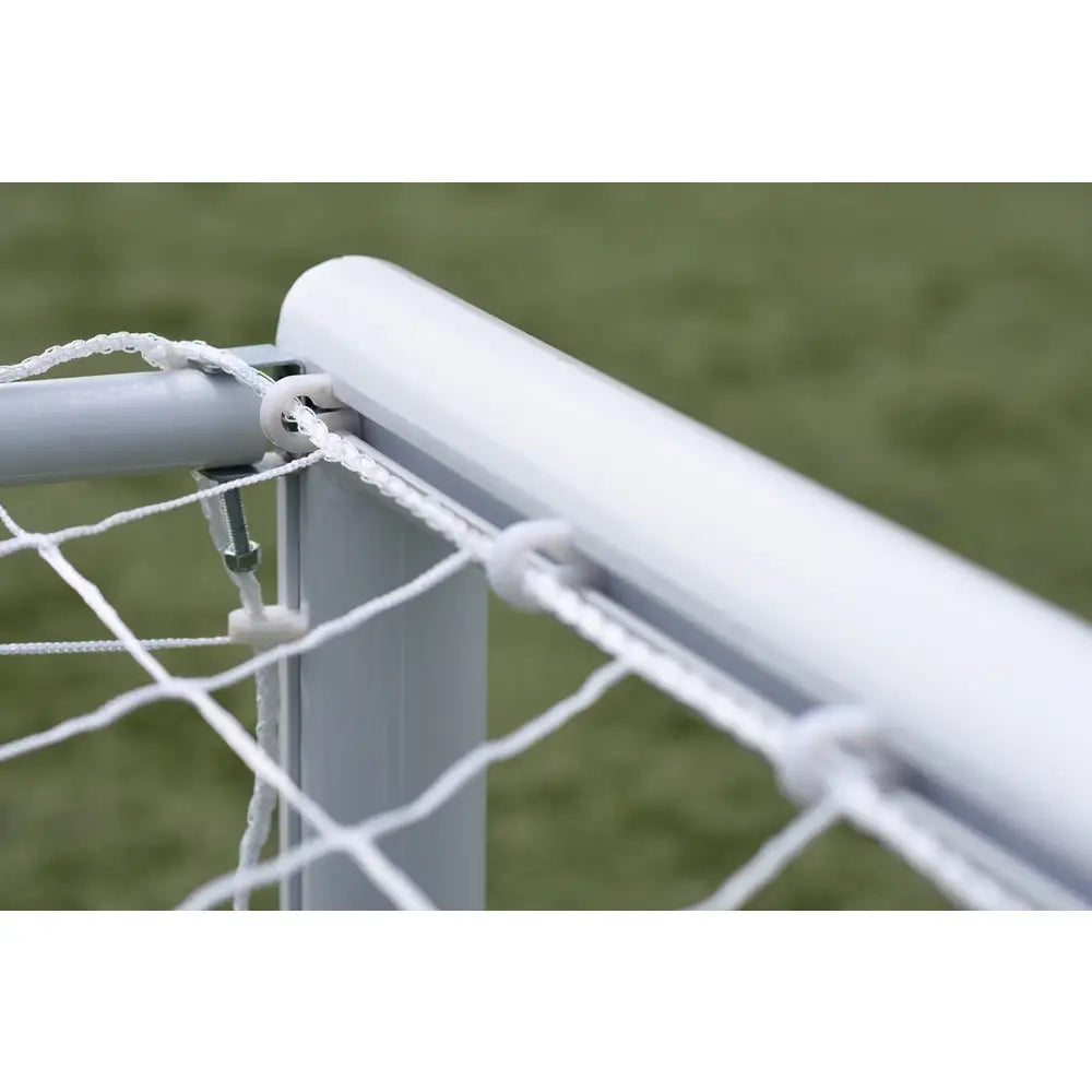 Port aluminium MINI PRO, detalj av hvit rammehjørne med netting, plastkroker og tauverk mot grønn bakgrunn.