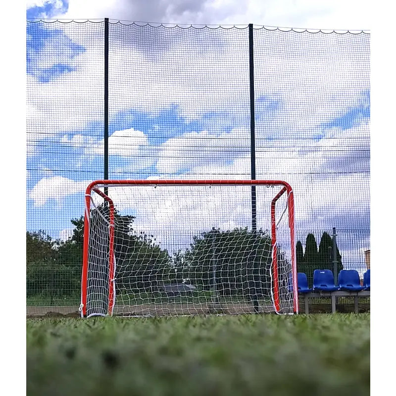 Port Economy fotballmål 120x80x60 cm, rød ramme og hvitt nett på gressbane, sett forfra med tribuner.