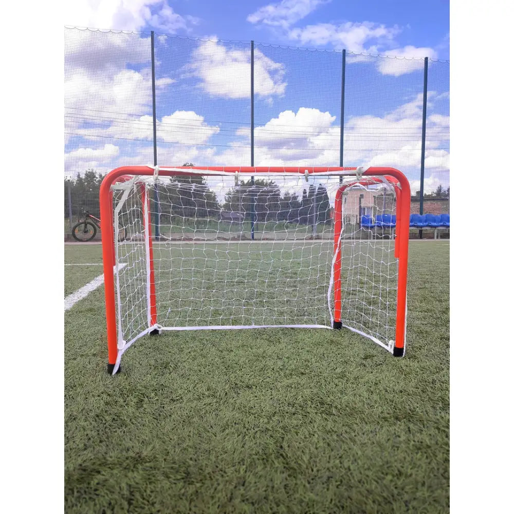 Port Economy fotballmål 90x60x40 cm, rød ramme og hvitt nett, frontbilde på grønn kunstgressbane.