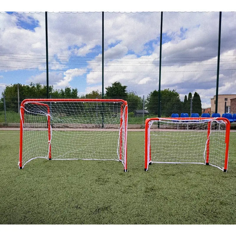 Port Economy fotballmål i to størrelser, røde rammer og hvite nett på kunstgressbane utendørs.