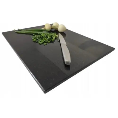 Premium svart granitt skjærebrett 30x40cm med kniv, hakkede urter og løk, sett skrått ovenfra.