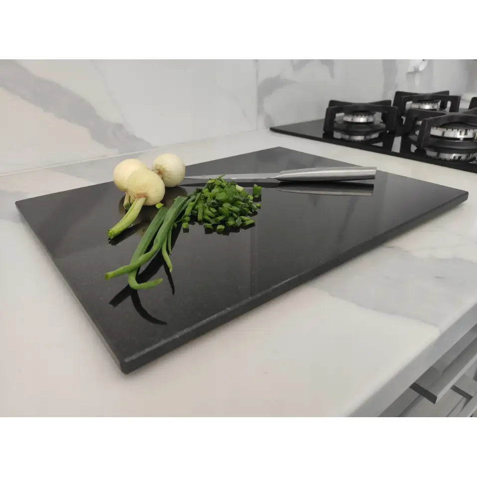 Premium svart granitt skjærebrett 30x40cm med vårløk, hakkede urter og kniv på lys kjøkkenbenk.