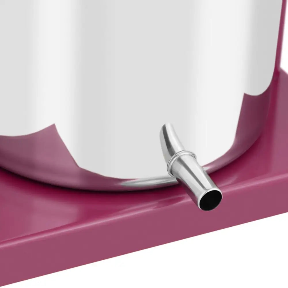 Press for fruktvin og juice, detaljert nærbilde av metallkran på rustfri beholder mot rosa underlag.