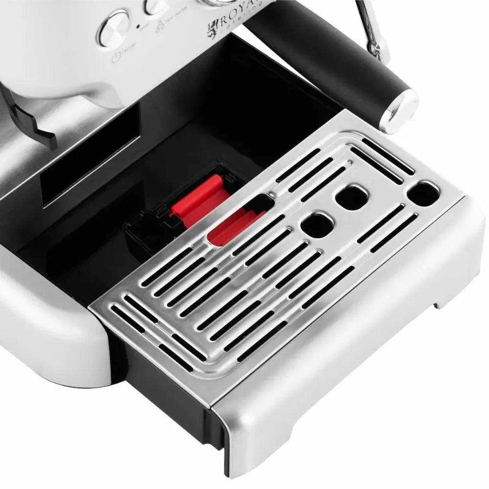 Dryppbrett til presskannekaffemaskin, nærbilde av perforert rist og rødt indikatorfelt sett ovenfra.