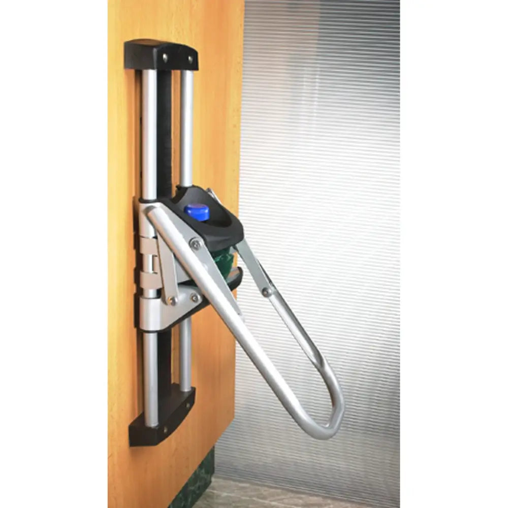 Pressmaskin EcoPress for PET-flasker, sidevisning montert på tredør med sort og blått håndtak.