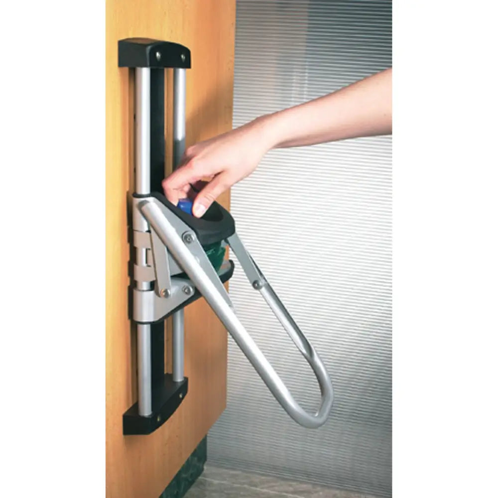 EcoPress pressmaskin for PET-flasker, nærbilde av sølvfarget håndtak montert på dør med synlige beslag.