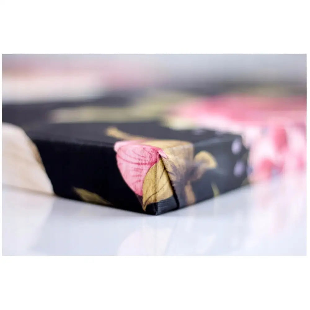 Nærbilde av hjørnet på Prinsesse med Enhjørning lerretsbilde med fargerikt blomstermønster mot mørk bakgrunn.