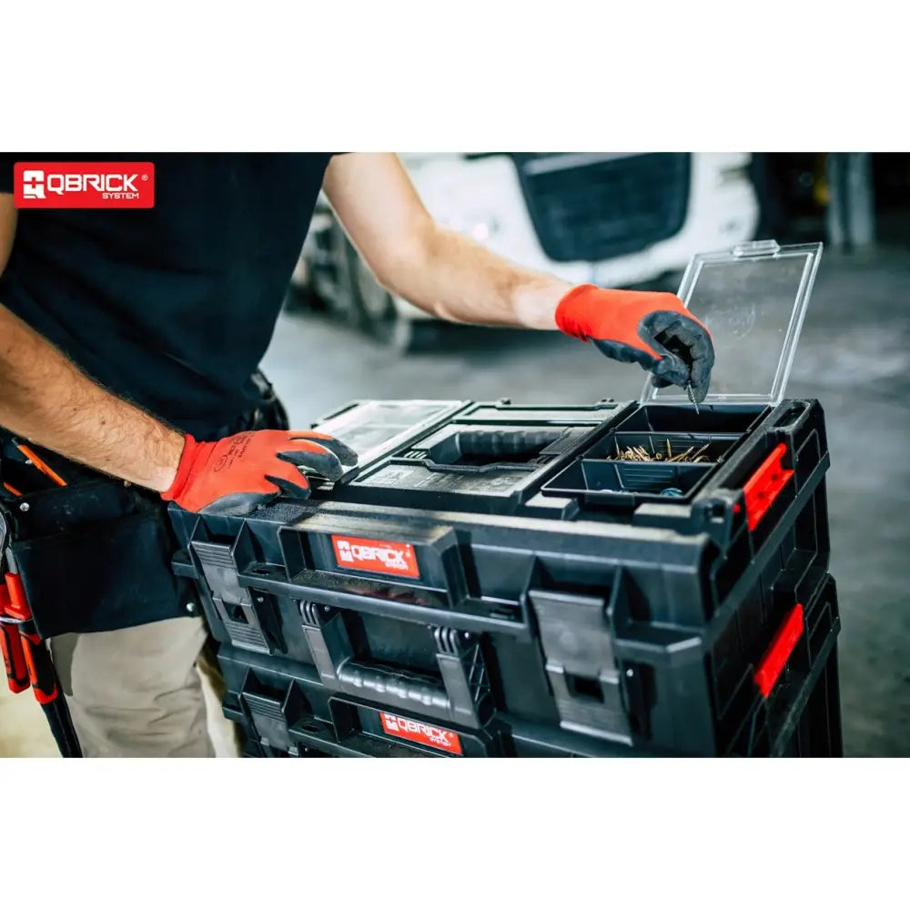 Qbrick System One Cart Techniker Set, åpen verktøykasse med småsortiment brukt av person med røde hansker.