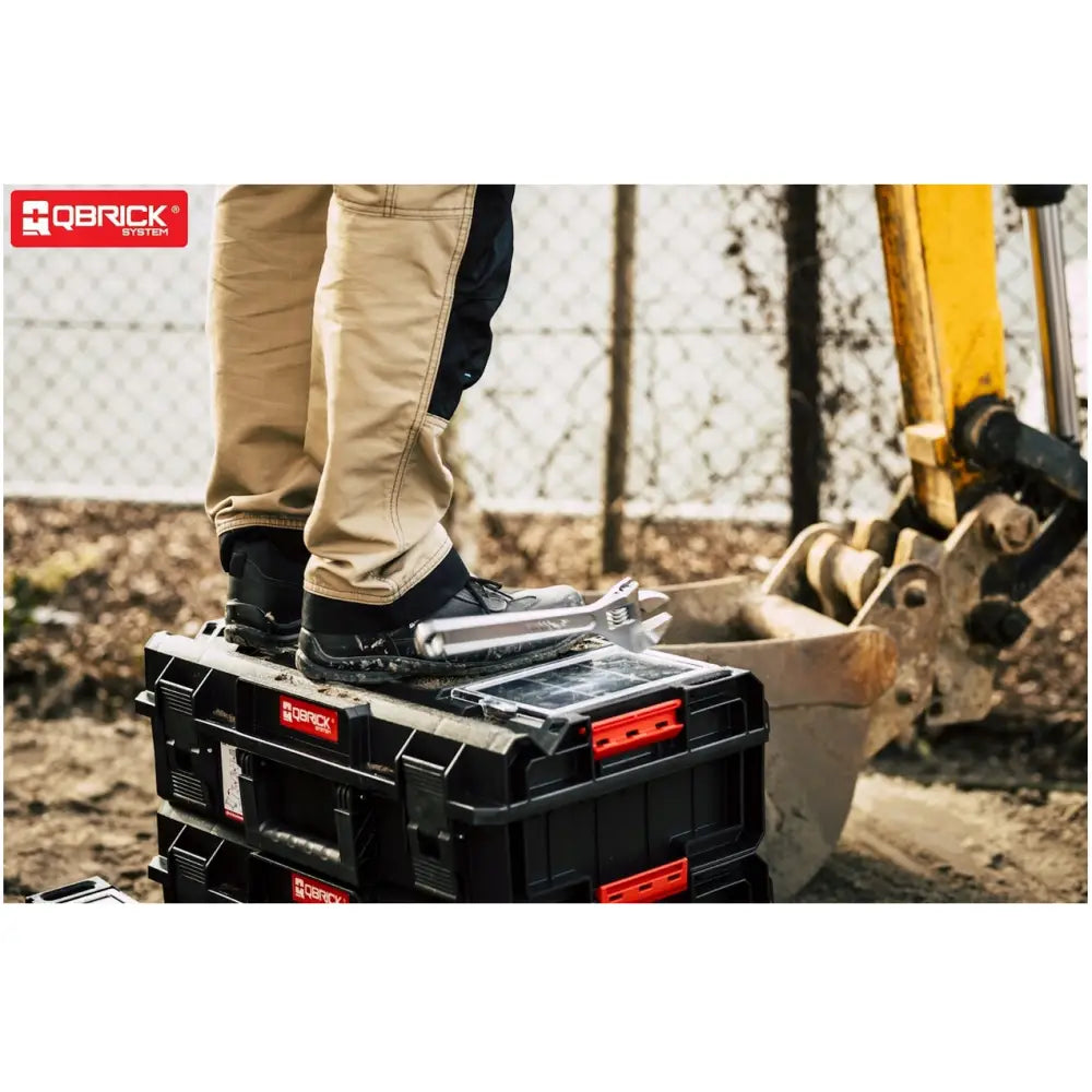 Qbrick System One Cart Techniker Set, to stablede svarte bokser med røde detaljer utendørs, person står på toppen.