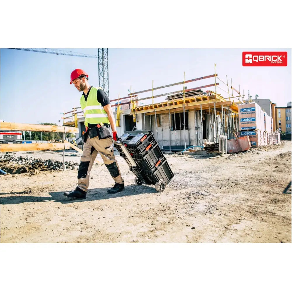 Qbrick System One Cart Techniker Set, trilles på byggeplass av arbeider med refleksvest og rød hjelm.