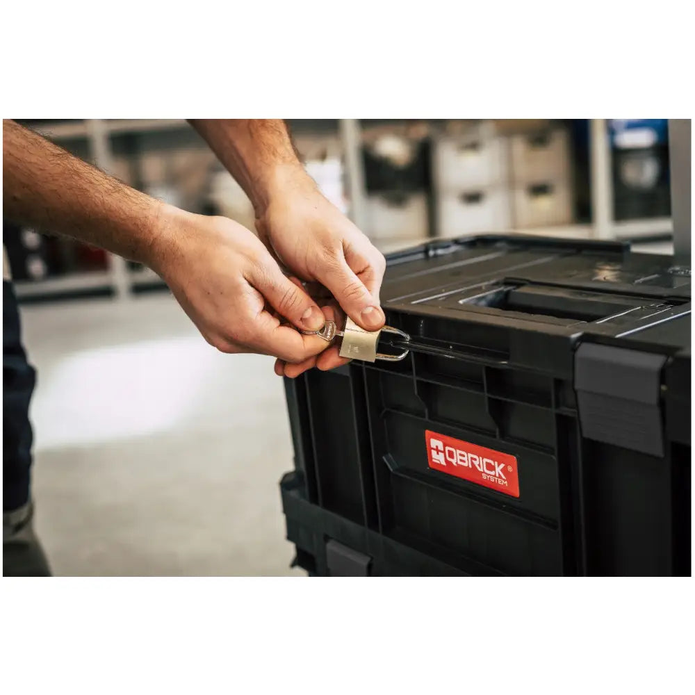 Qbrick verktøykasse sett Two, sidevisning med rød logo, hengelås og nøkkel i bruk for sikker lukking.