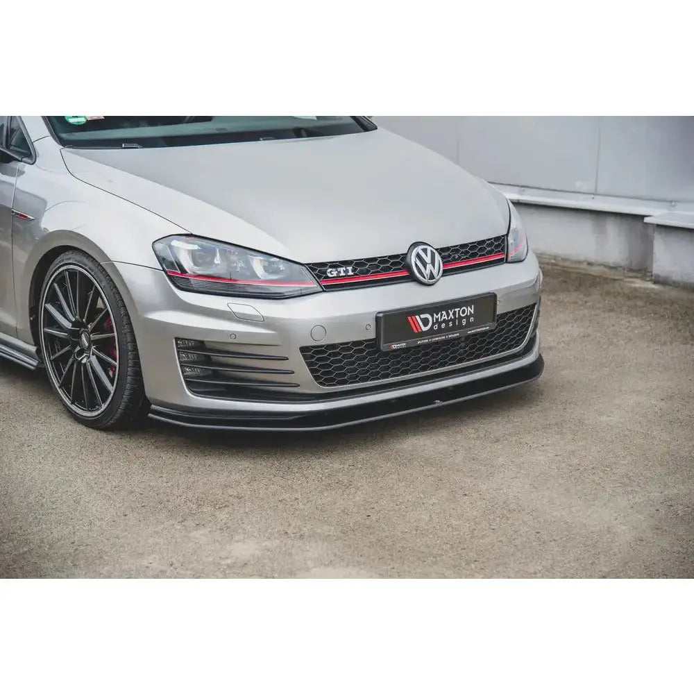 Front lip på VW Golf 7 GTI, sølvfarget bil med rød stripe og sort frontspoiler nederst på støtfanger.
