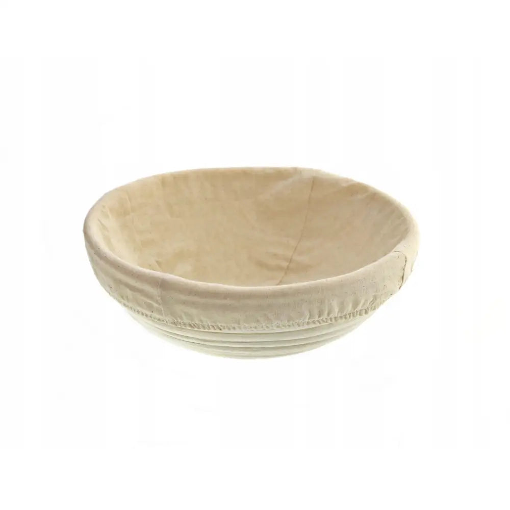 Rattankurv for heving av brød, rund modell med lyst tøytrekk, sett fra skrå vinkel mot hvit bakgrunn.