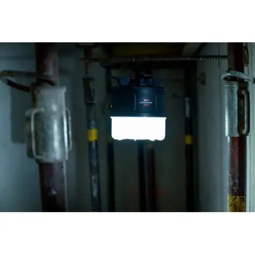 Reflektor LED 360°, sort arbeidslampe som henger fra metallrør og lyser sterkt ned i mørkt industrilokale.