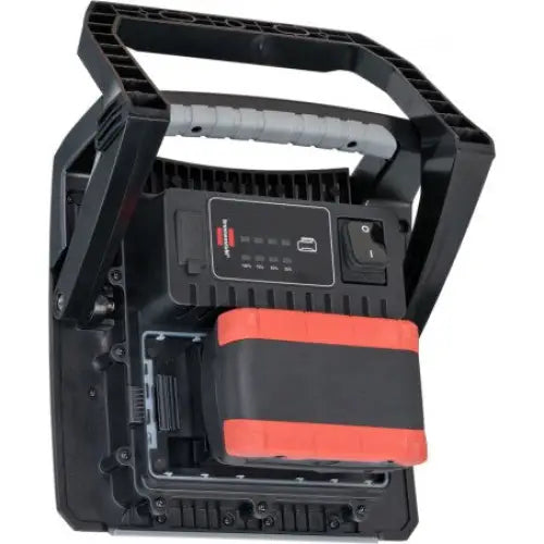 Reflektor LED arbeidslampe bakfra, viser batteripakke, robust bærehåndtak med grått grep og ladeindikator.