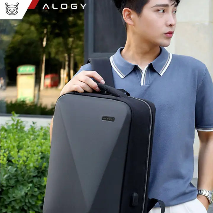 Sort laptopveske med matt finish og diskret logo, bæres av ung person med håndtak, sidevisning.