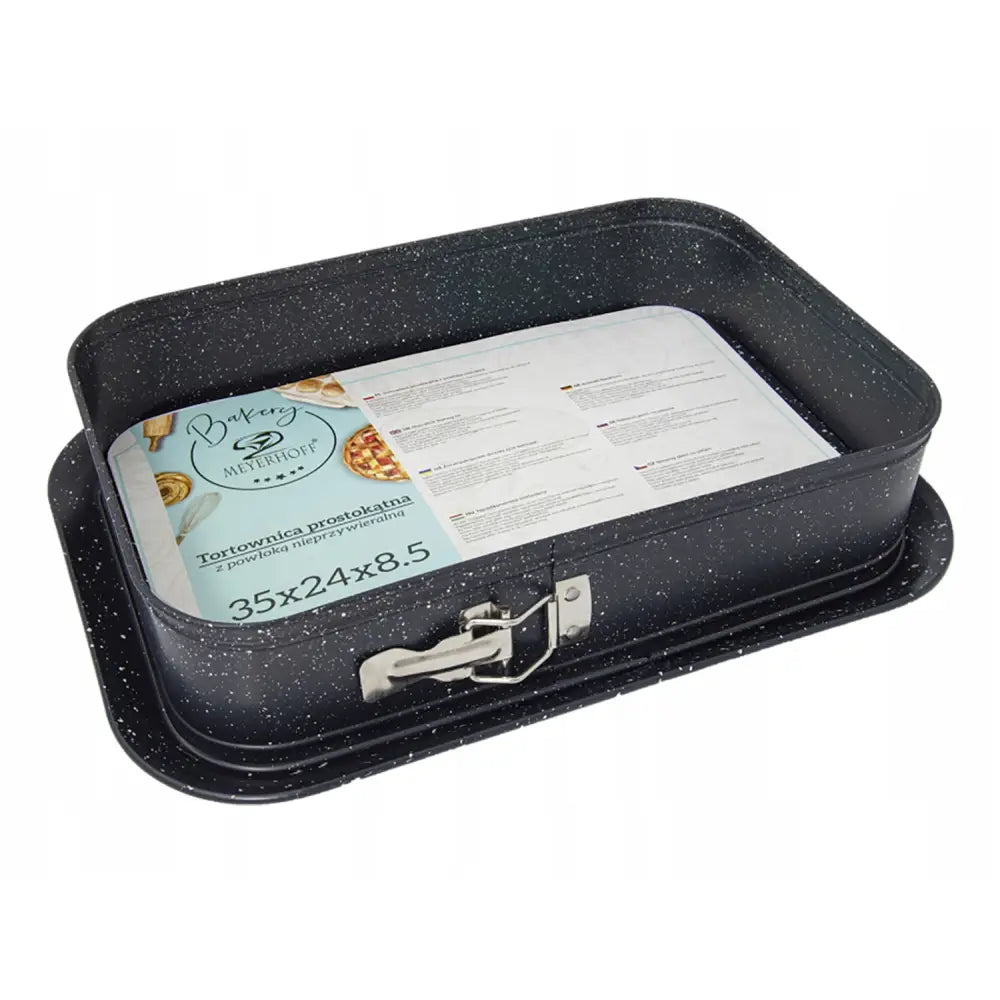 Rektangulær bakeplate med hvite prikker, metallås på siden og informasjonsark liggende inni formen.