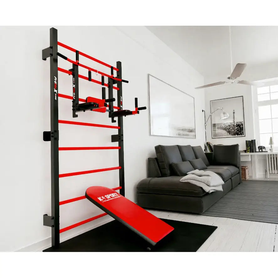 Ribbevegg med parallelle barer og rød treningsbenk, sett fra skrå vinkel mot stuevegg med sofa i bakgrunnen.