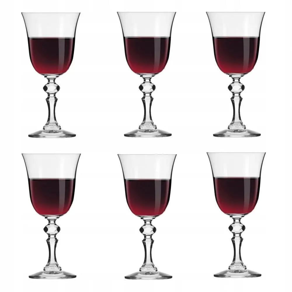 Rødvinsglass i glass, sett med fem glass fylt med rødvin og fasetterte stetter mot hvit bakgrunn.