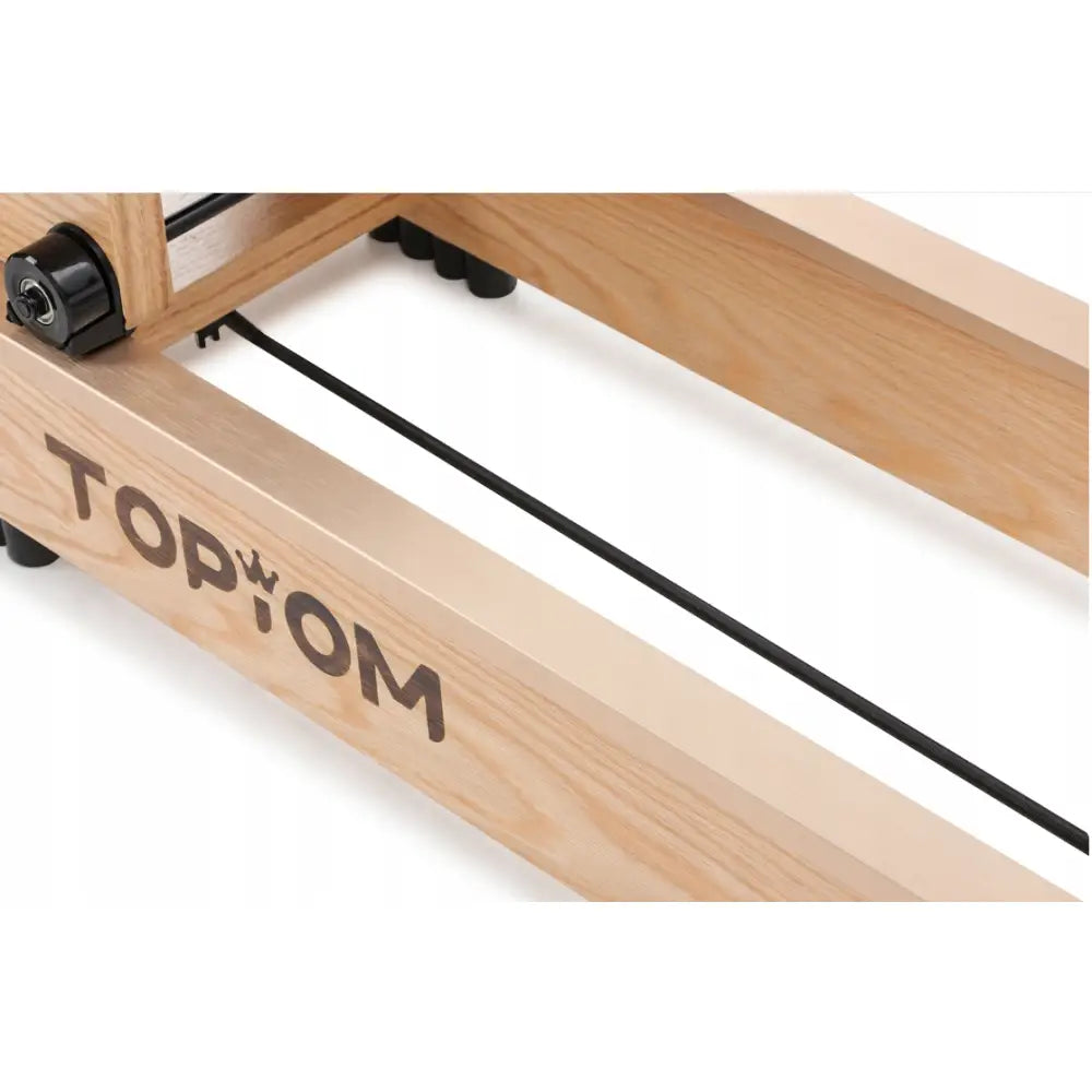 Romaskin i lyst treverk med sorte detaljer, sett fra siden og ovenfra, fremhever robust materialvalg og design.