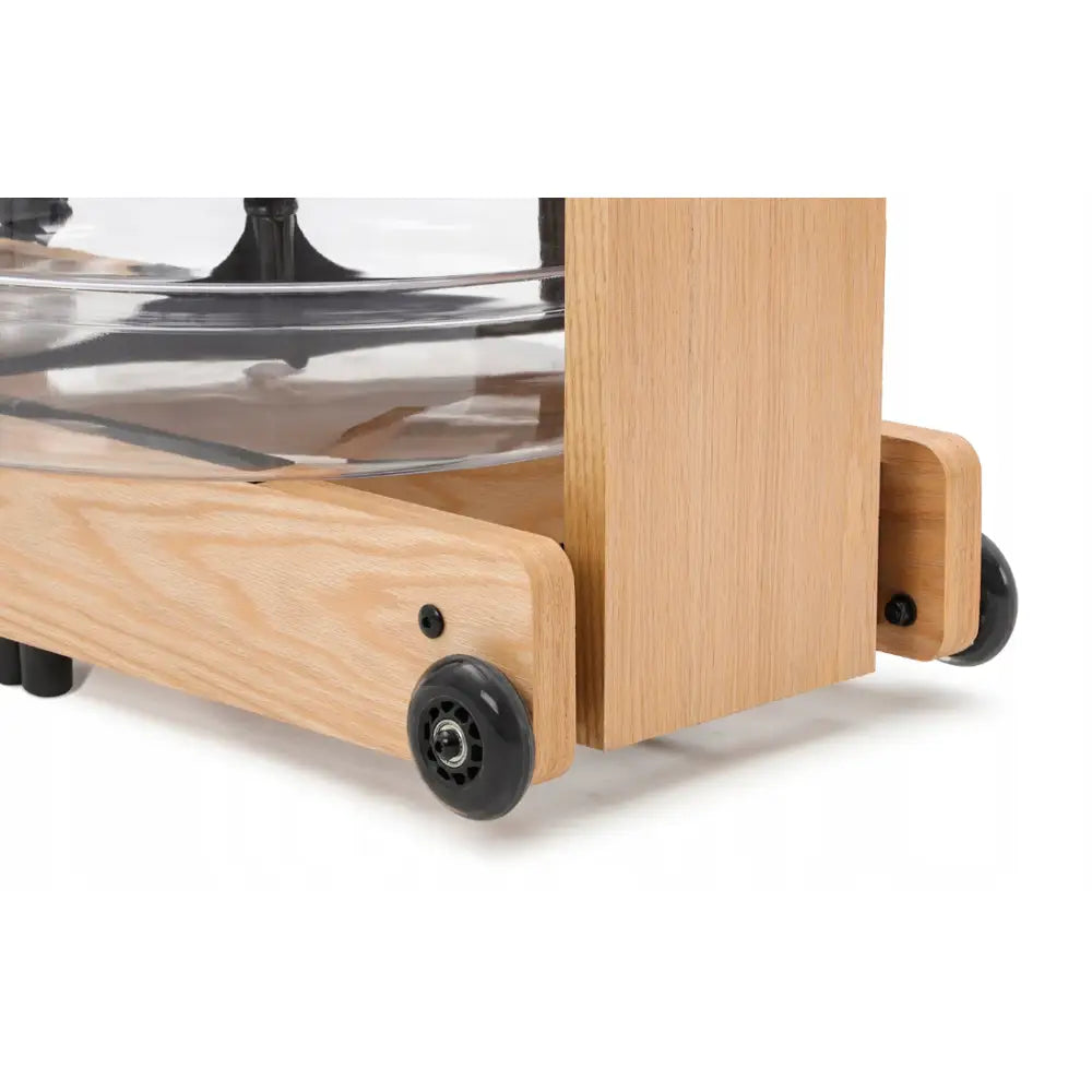 Romaskin i lyst treverk, nærbilde av base med fire svarte hjul og gjennomsiktig vanntank over.