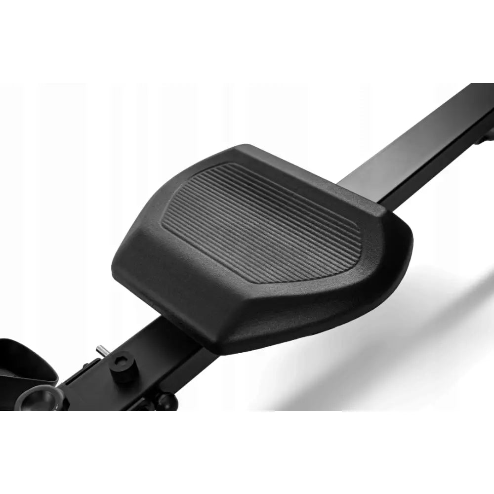 Romaskin Omega, nærbilde av sort plastsete med riflet overflate på metallskinne sett fra skrå vinkel.