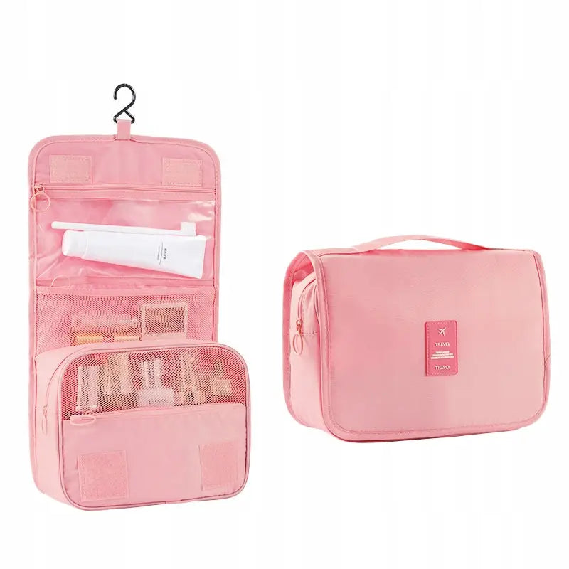 Romslig utleggbar rosa toalettmappe i tekstil, vist åpen med lommer, glidelåser og opphengskrok.