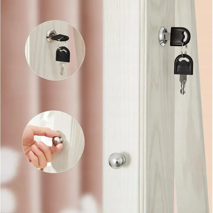 Roterende smykkeskap, detalj av nøkkellås i metall med to svarte nøkler og hånd på håndtaket.