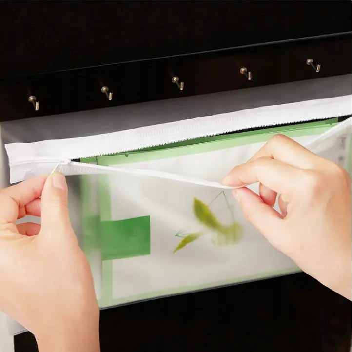 Gjennomsiktig oppbevaringspose med hvit glidelås åpnes, grønt og hvitt innhold skimtes gjennom plasten.