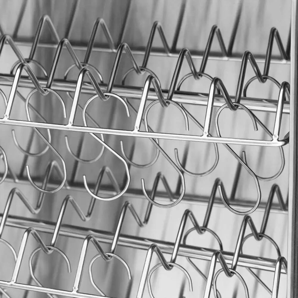 Røykovn med seks hyller, nærbilde av blankt metallstativ med S-formede kroker i flere rekker.