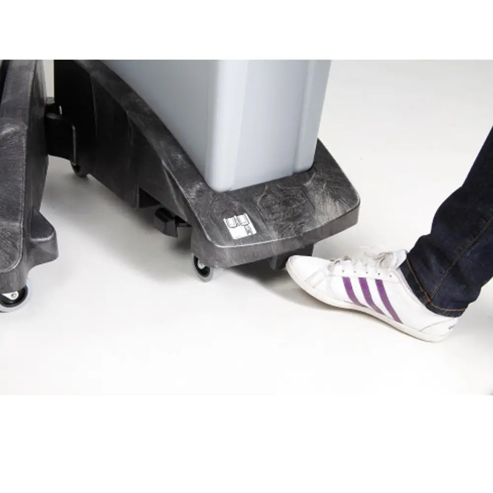 Rubbermaid SLIM JIM avfallskasse understell, sidevisning av pedalaktivering med fot og synlige hjul.