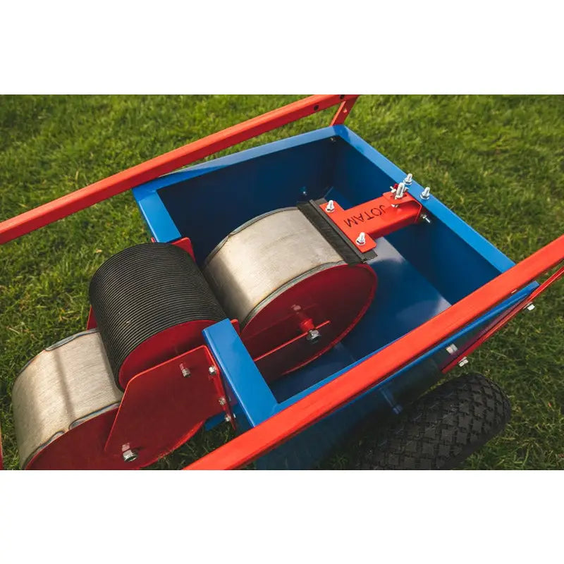 Rulleskate for linjemaling, nærbilde av blå og røde ruller med metallramme på gress, sett ovenfra.