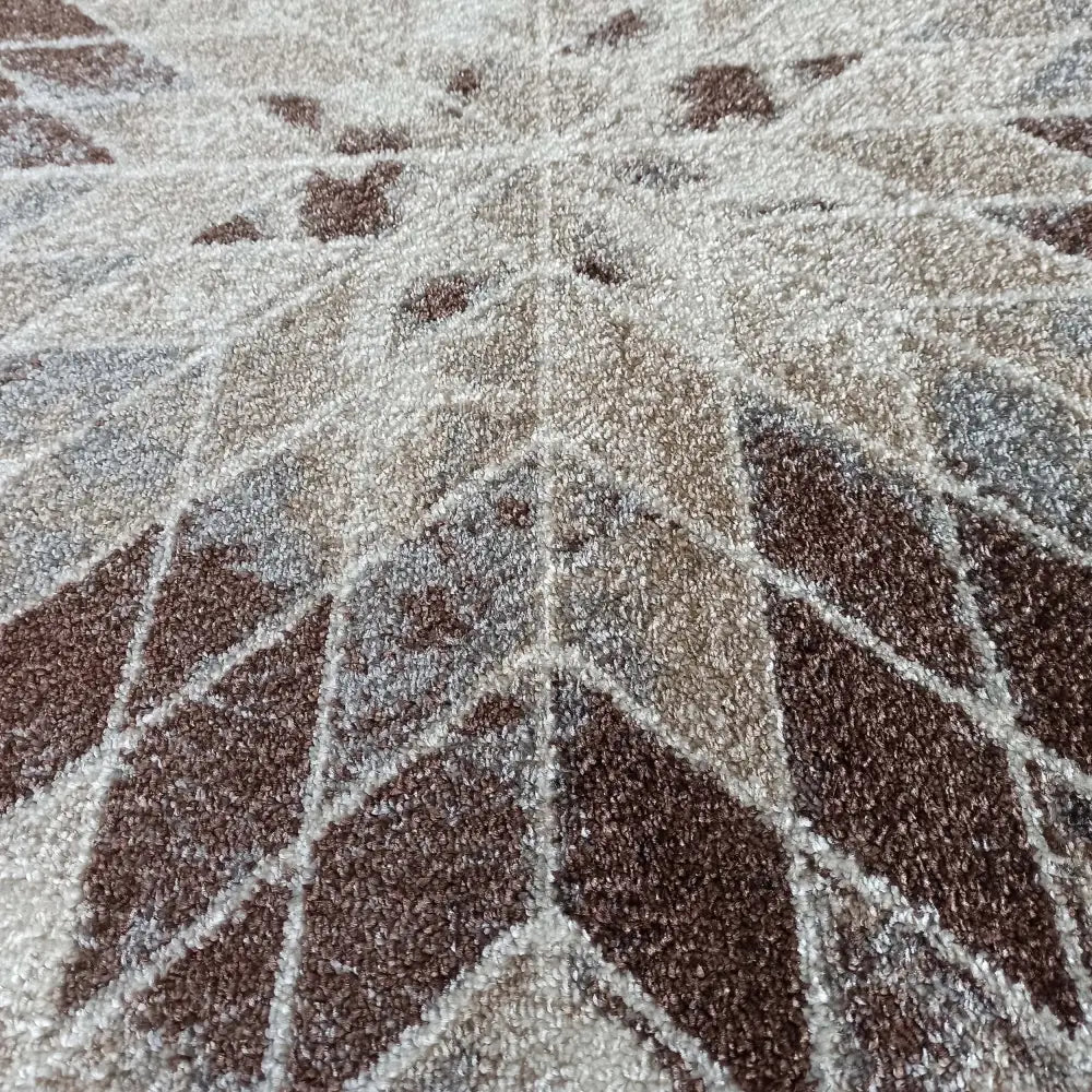 Rundt brunt teppe Panama, nærbilde av strukturert overflate med geometrisk mønster i beige og brunt.