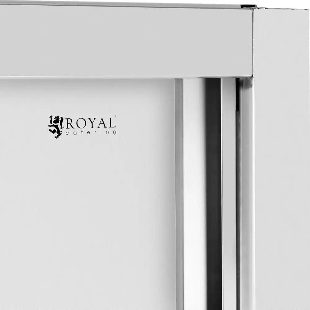 Rustfritt stål skyvedørskap, nærbilde av hjørne med Royal Catering-logo og detaljerte metallflater.