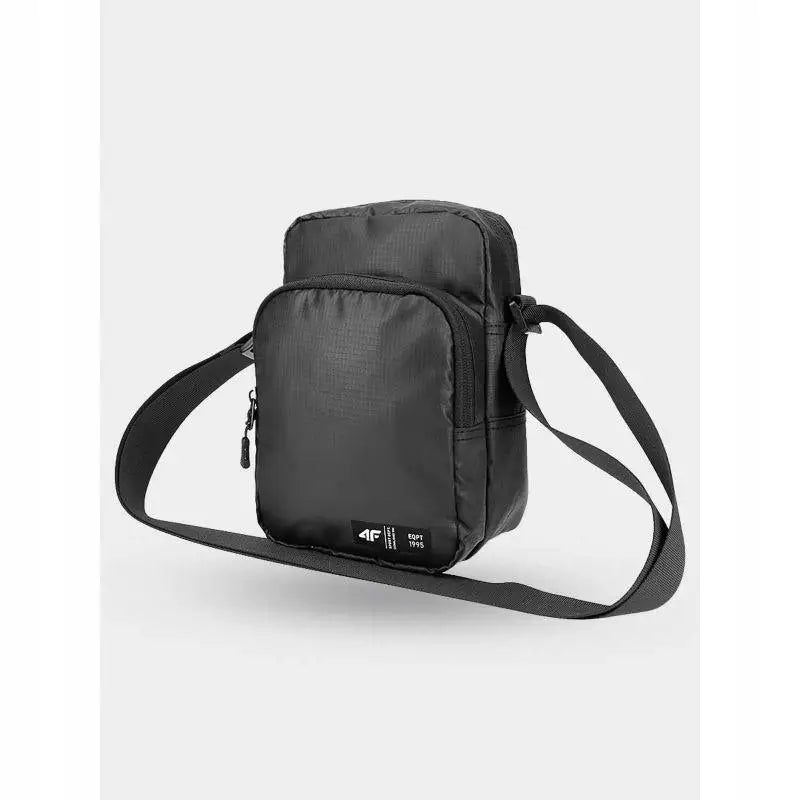 Svart skulderveske i nylon med synlig glidelåslomme, justerbar rem og liten logo på fronten.