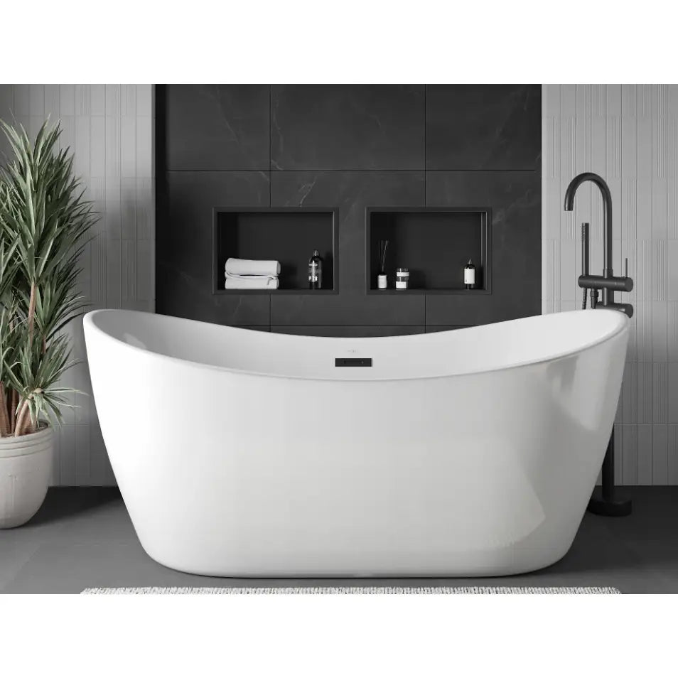 Frittstående hvitt badekar med ovale former, sort gulvstående blandebatteri og nisjehyller i mørk baderomsvegg.