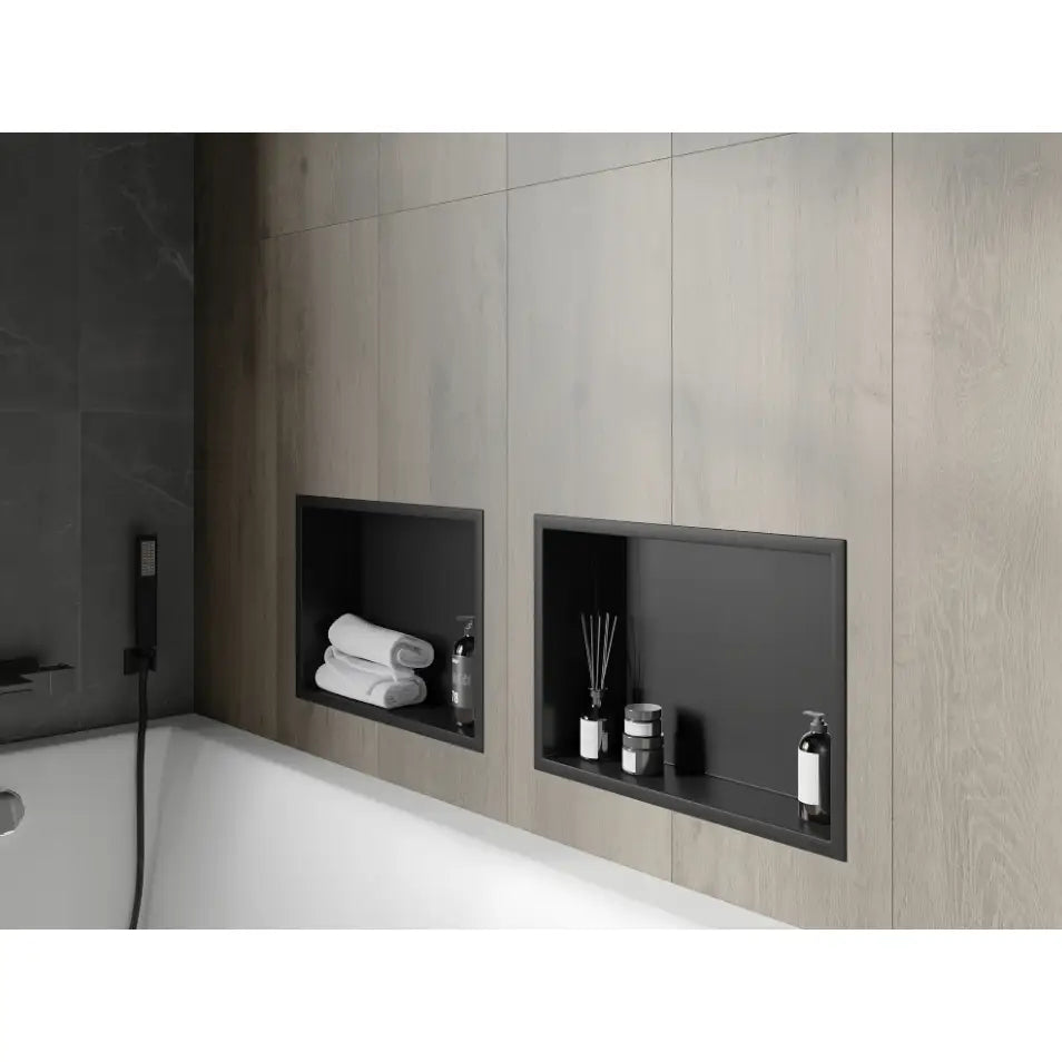 Mexen X-Wall-R nisjehylle i svart, montert i lysegrå vegg over badekar med håndklær og såpedispenser.